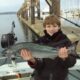 Young angler holding a Chinook salmon during Seattle’s early spring salmon season
