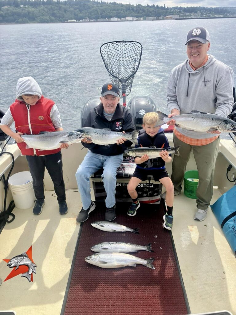 Family holding Coho salmon during a September fishing charter on Puget Sound with All Star Fishing Charters